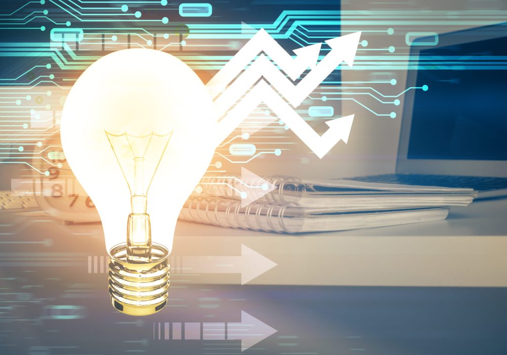 Computer on desktop in office with bulb icon hologram. Multi exposure. Concept of idea.